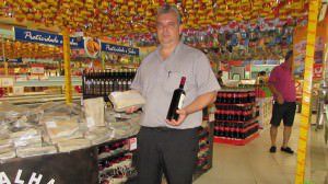 O gerente de supermercado Fábio Luchiens mostra produtos como o vinho e o bacalhau que devem deixar a mesa e as celebrações mais caras na Páscoa. Foto: Fábio Barcelos